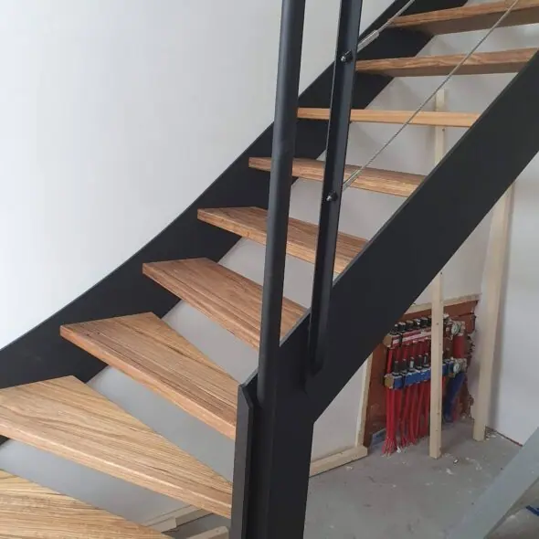 Zwarte metalen trapbomen houten treden